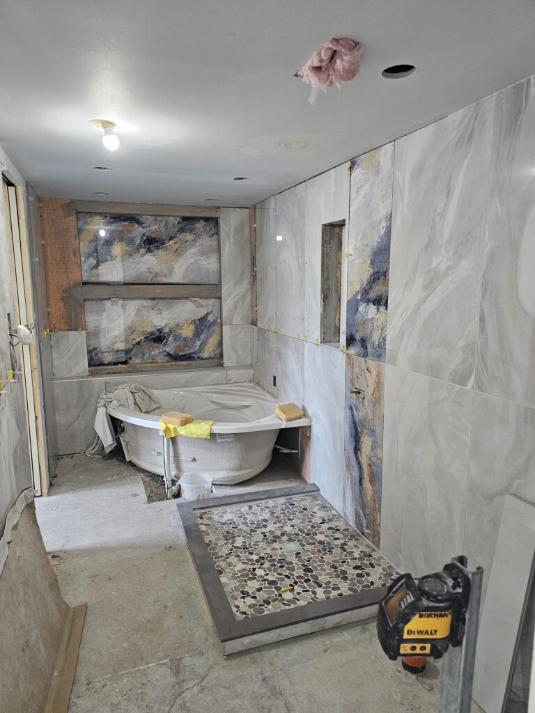 Luxury bathroom renovation with natural stone and pebble tile
